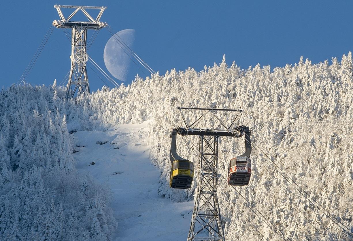 Tram cars meet as the half-moon rises over cannon