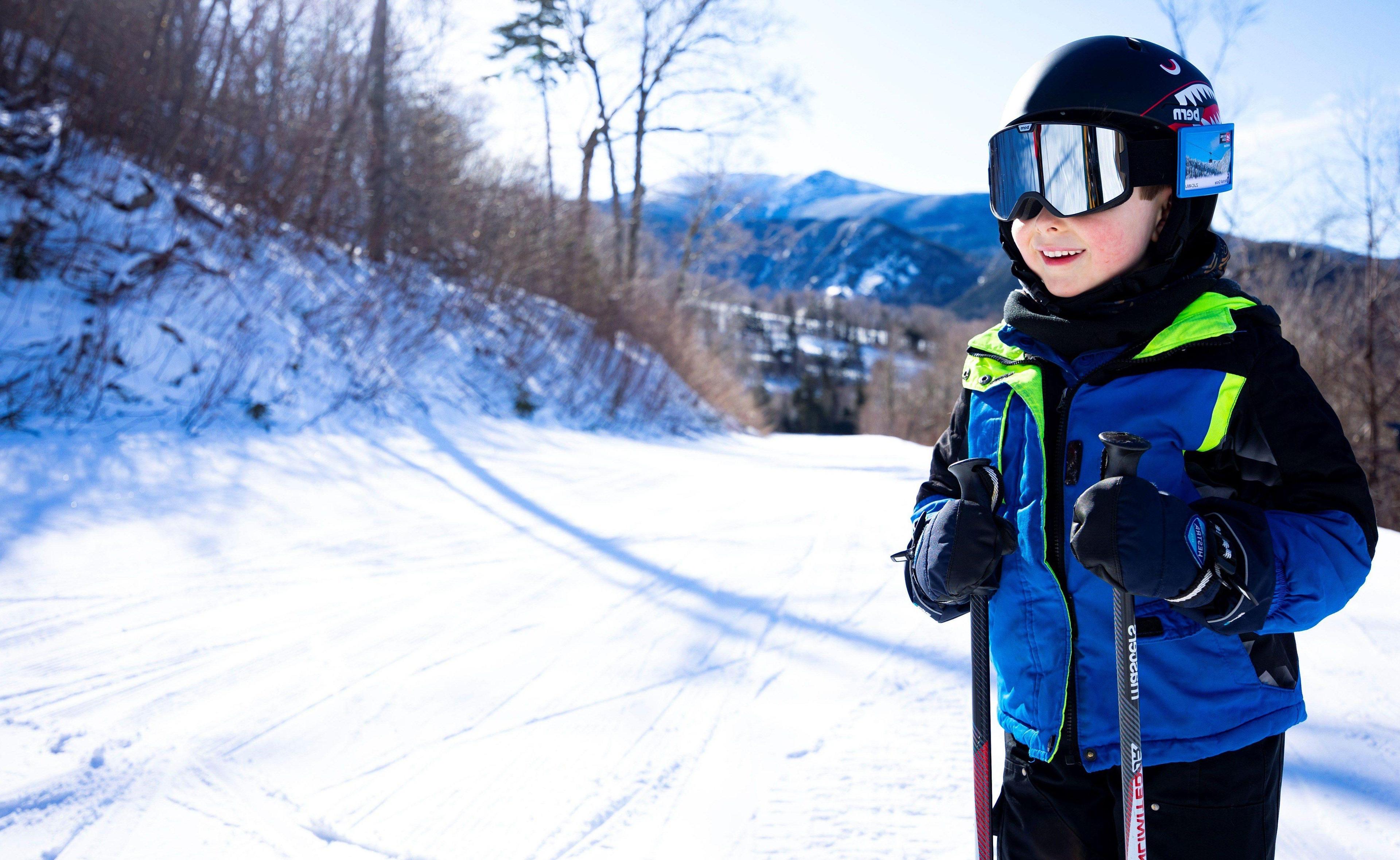 Child wearing blue ski jacket and mirrored goggles