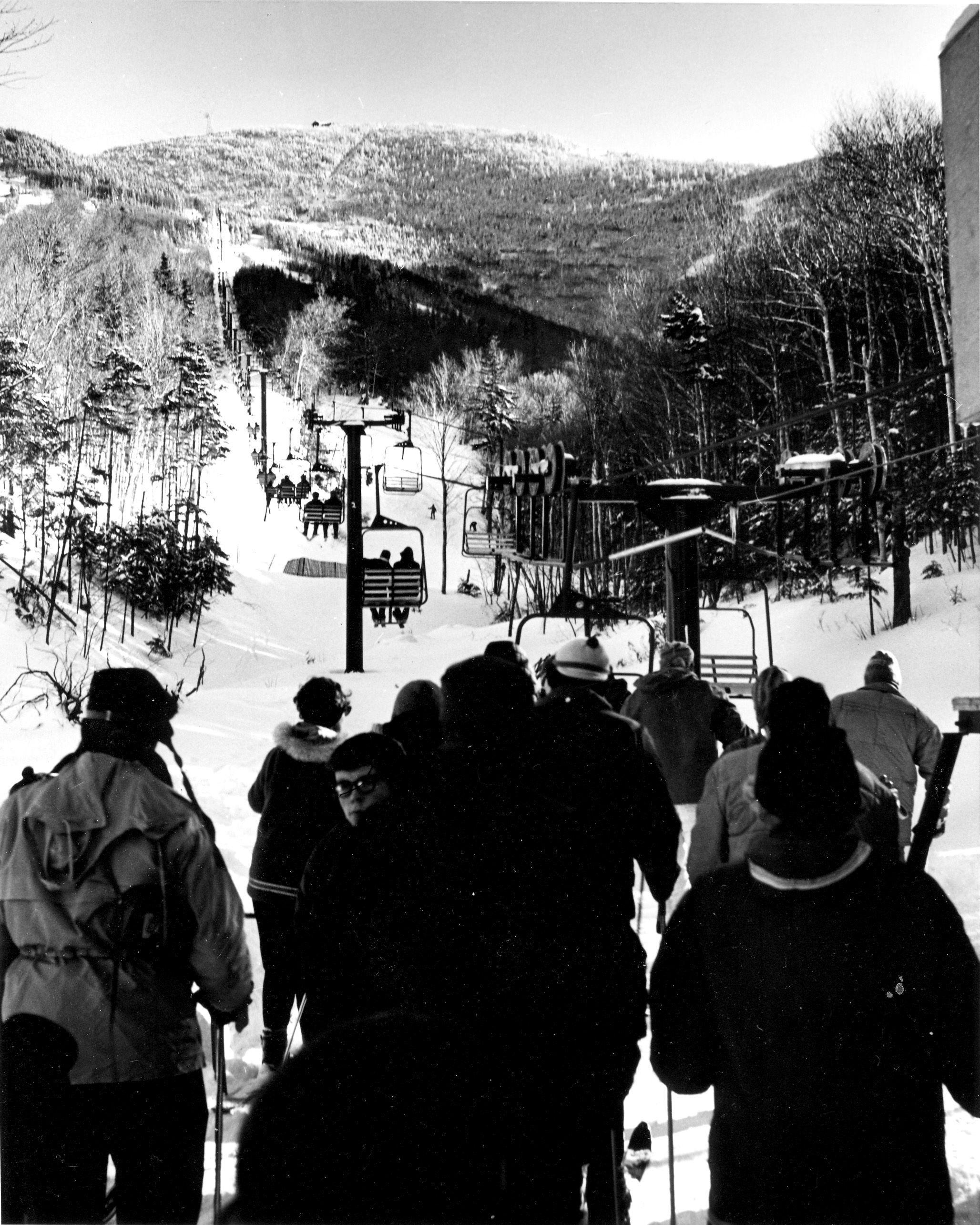 Skiers stand at the base of the old Peabody double. black and white photo